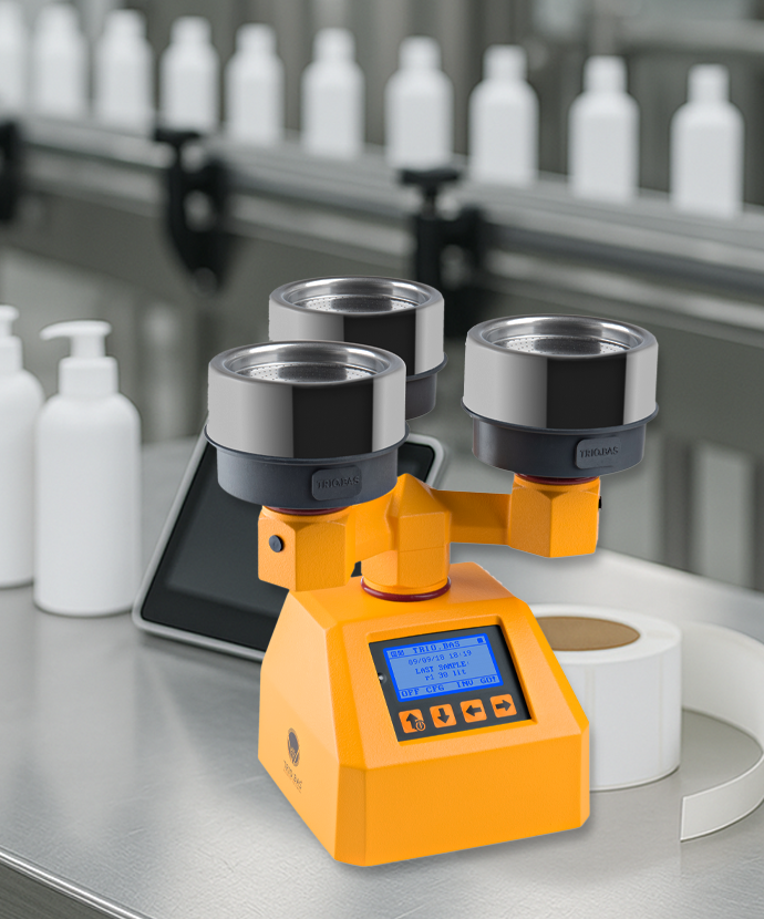 AIRBIO TRIO Luftkeimsammler auf Edelstahltisch in einer Produktionslinie der Kosmetikindustrie mit Etikettendrucker und Verpackungseinheit